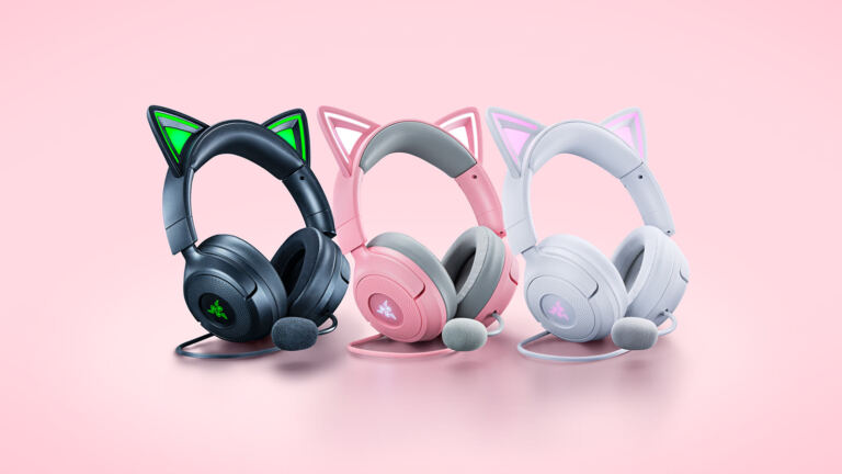 Três headsets Razer Kraken Kitty V3 nas cores preta, rosa e branca, com orelhas de gato iluminadas